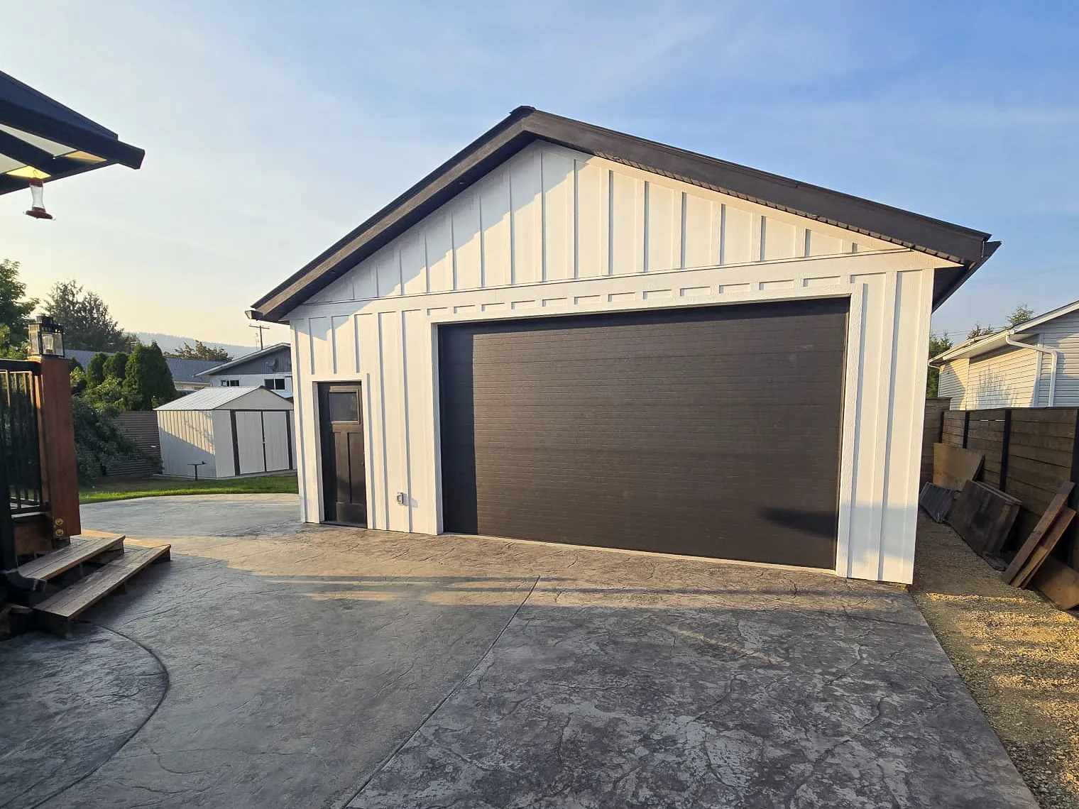 Detached garage with new siding and a stamped concrete driveway